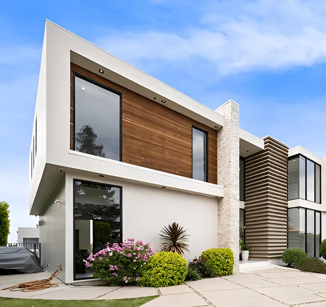 Wide view of a modern residence with timber cladding and landscaped grounds